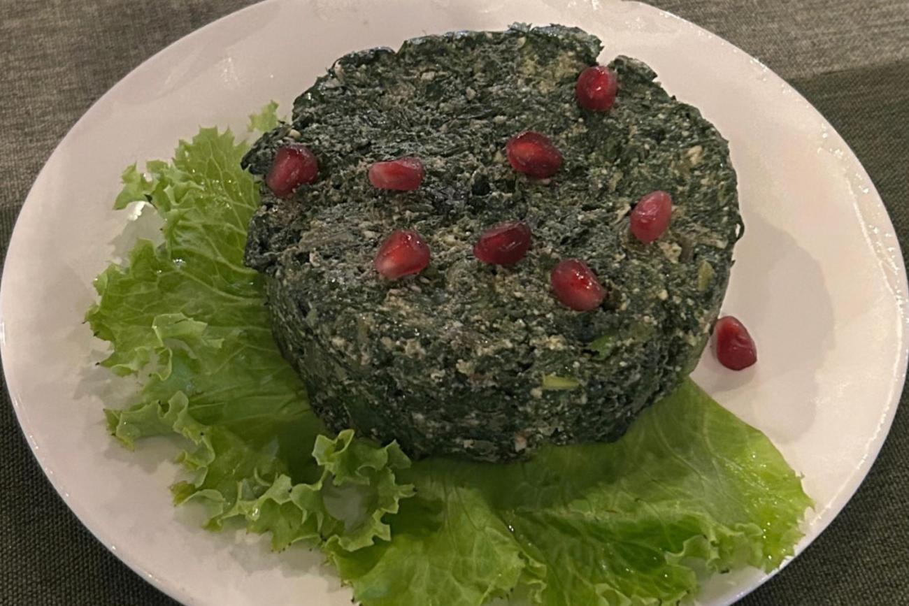 A rounded serving of pkhali, made with an array of vegetables like beetroot, pumpkin and cabbage